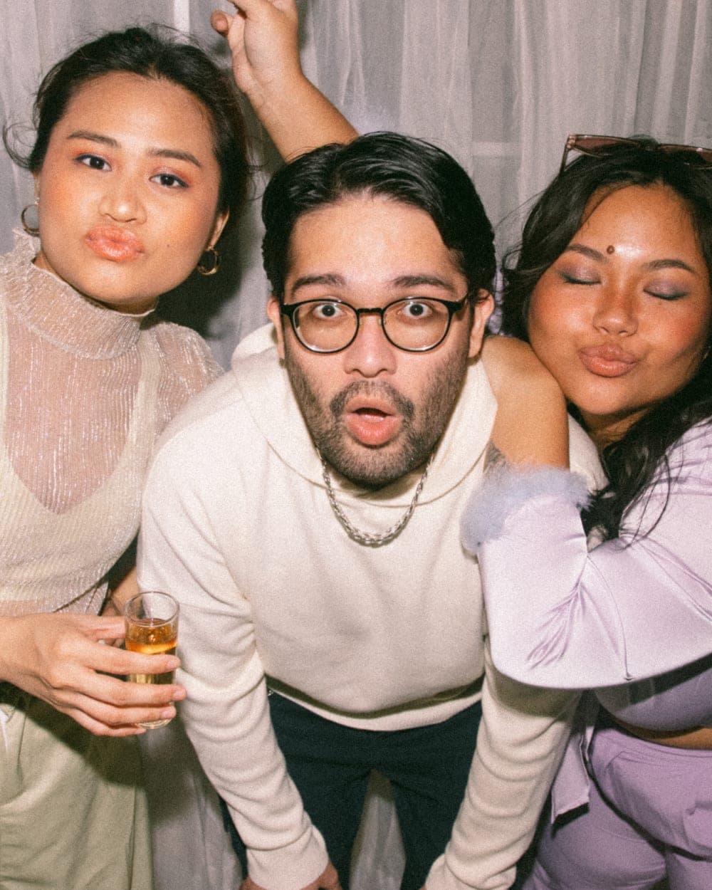 Three friends mugging playfully for the camera at a party